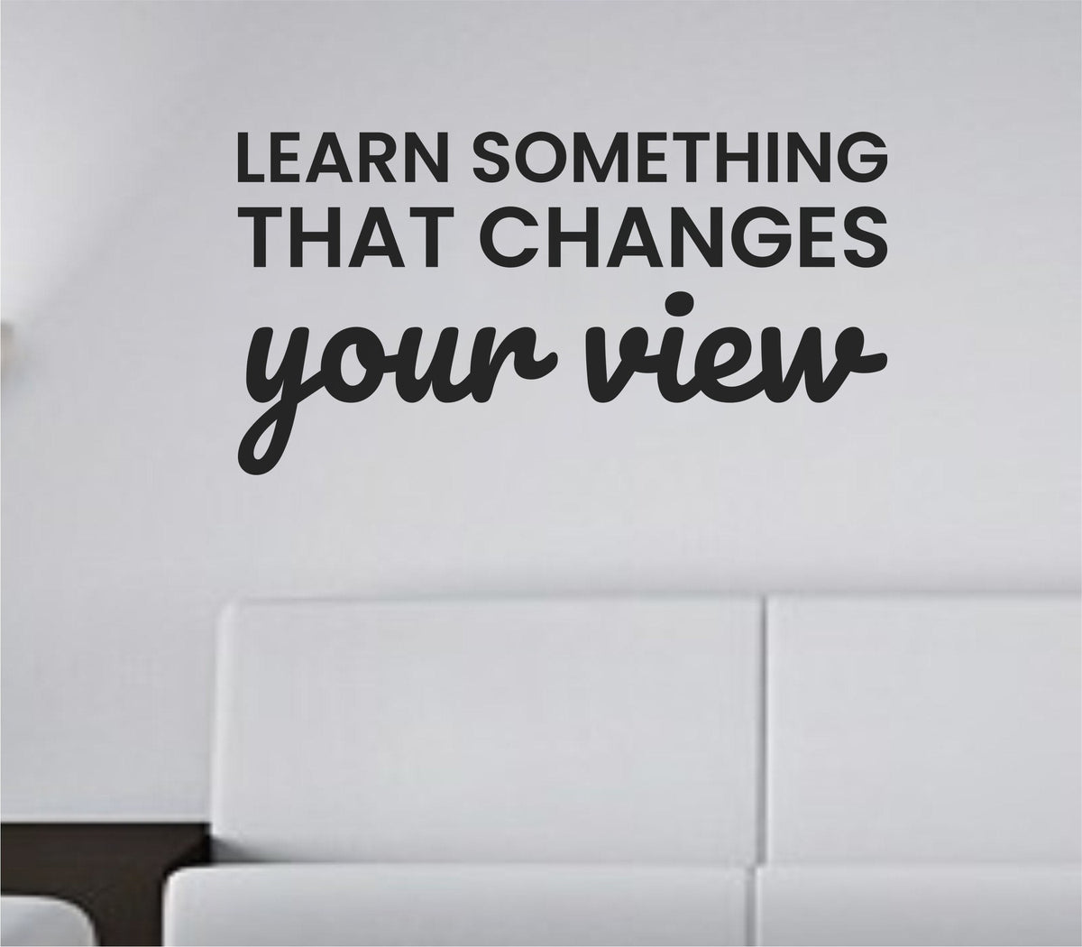 Black vinyl wall decal with the quote Learn something that changes your view in clean, bold lettering on a white background.