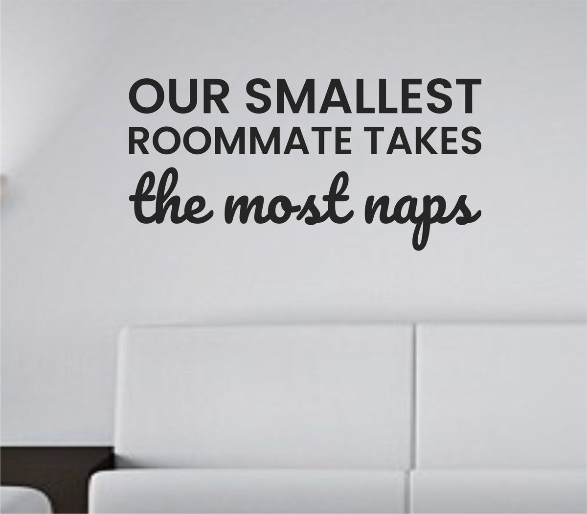 Black vinyl wall decal with the phrase Our smallest roommate takes the most naps in playful, bold lettering on a white background.