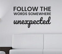 Black vinyl wall decal displaying the phrase Follow the words somewhere unexpected in a clean modern font on a white background.