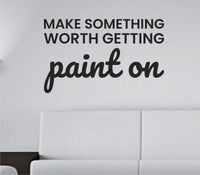 Black vinyl wall decal with the quote 'Make something worth getting paint on' in bold, simple font on a white background.