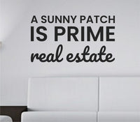 Black vinyl wall decal with the quote 'A sunny patch is prime real estate' in clean modern font on a white background