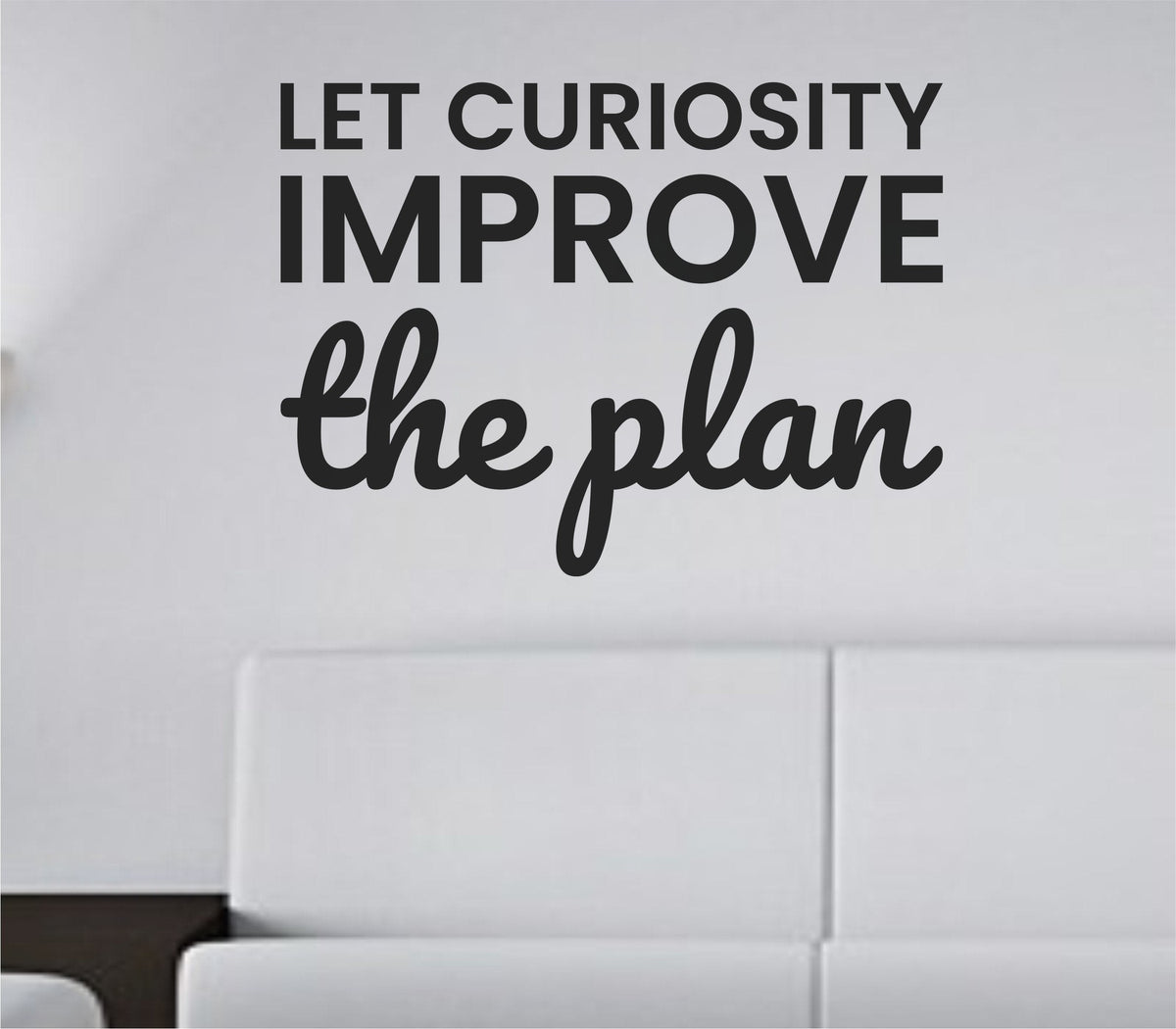 Black vinyl wall decal with the quote Let curiosity improve the plan in modern clean typography on a white background.