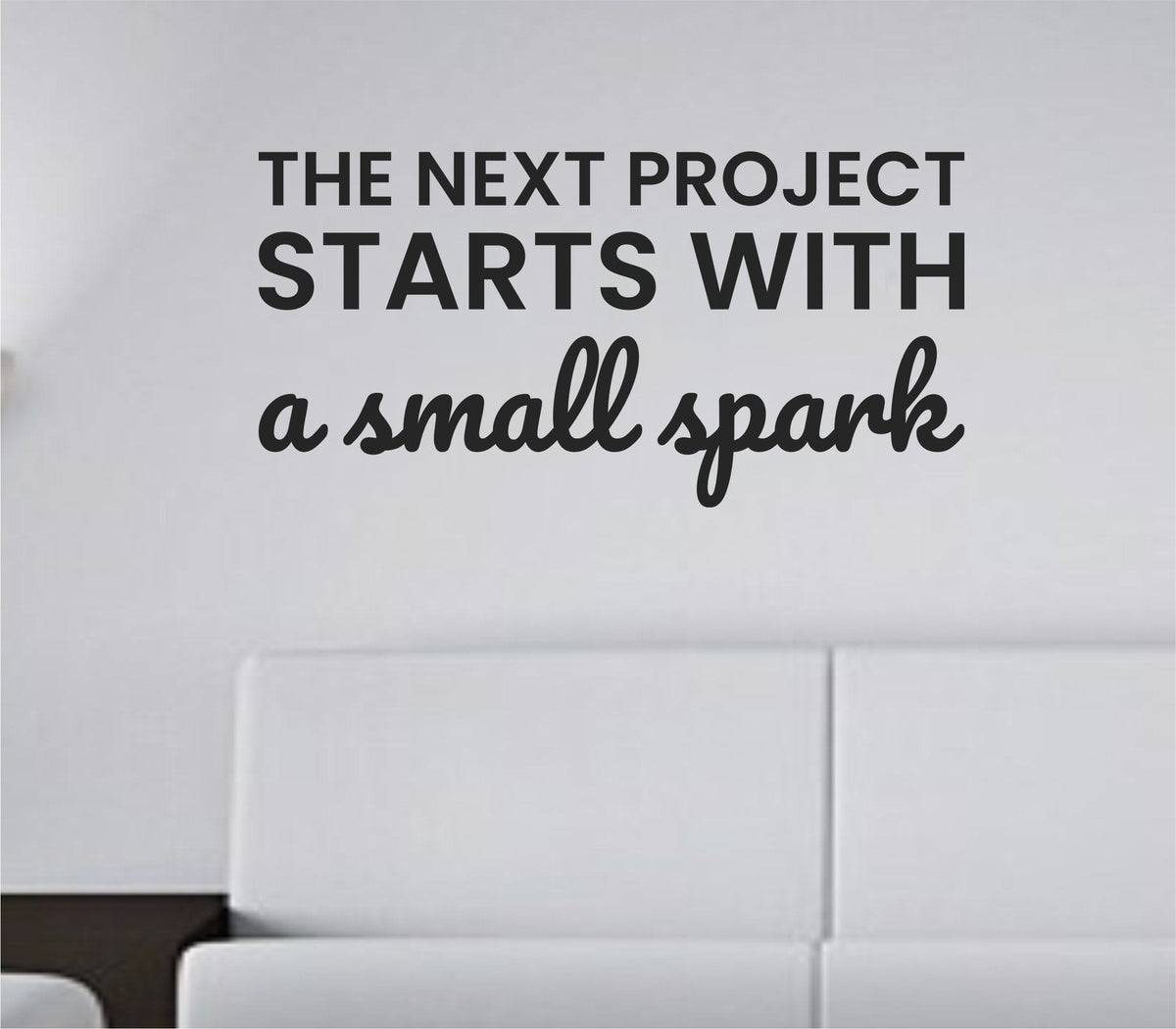 Black vinyl wall decal of the quote 'The next project starts with a small spark' in simple modern typography on white background