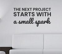 Black vinyl wall decal of the quote 'The next project starts with a small spark' in simple modern typography on white background