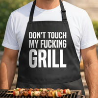 Black apron with bold white text reading Don't Touch My Fucking Grill in all caps, simple and direct design.
