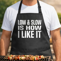 Black apron with large white block text reading Low And Slow Is How I Like It in bold font