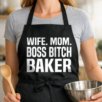 Black apron with large bold white text saying Wife Mom Boss Bitch Baker in a stacked layout
