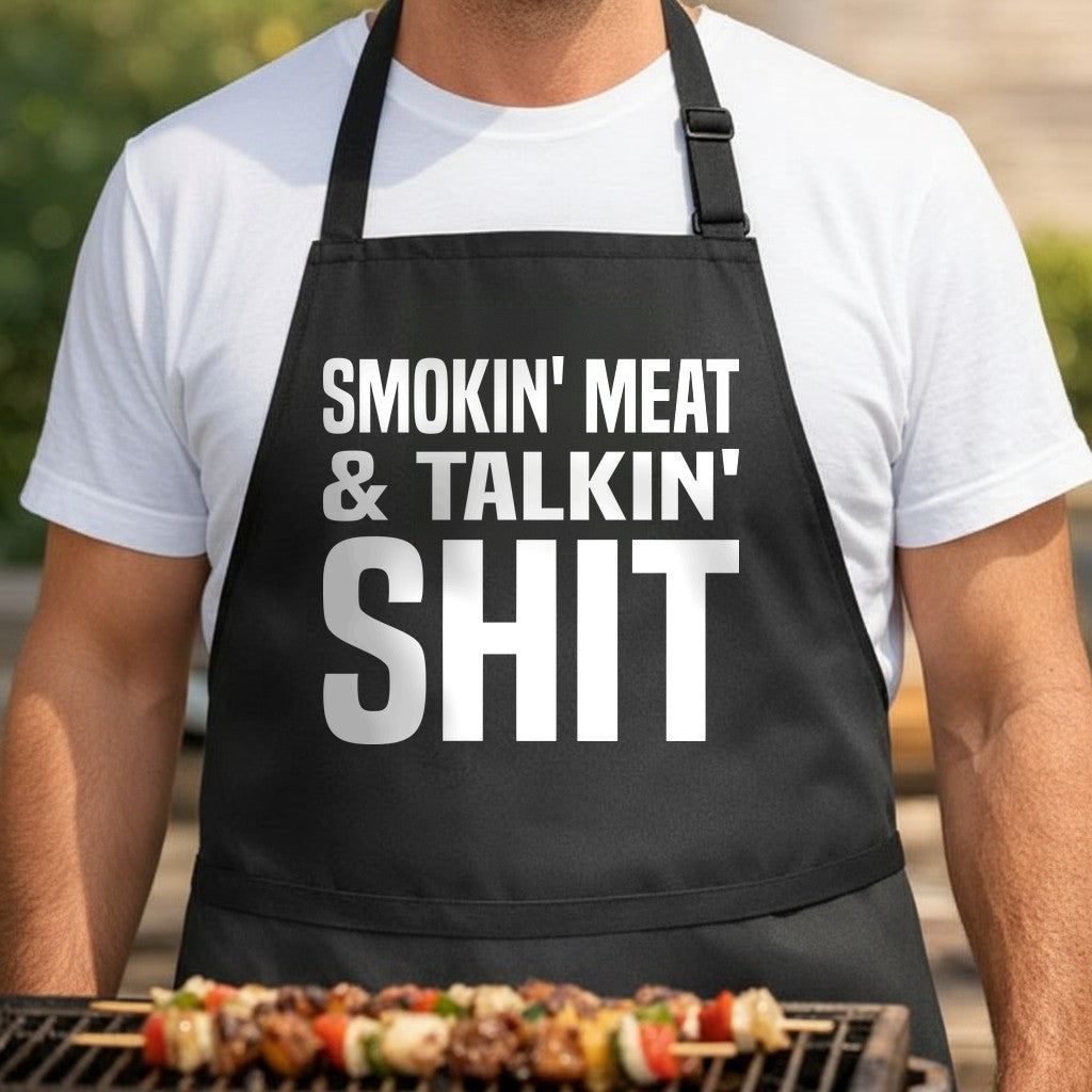 Black apron with bold white text reading 'Smokin' Meat & Talkin' Shit' in large block letters, simple design