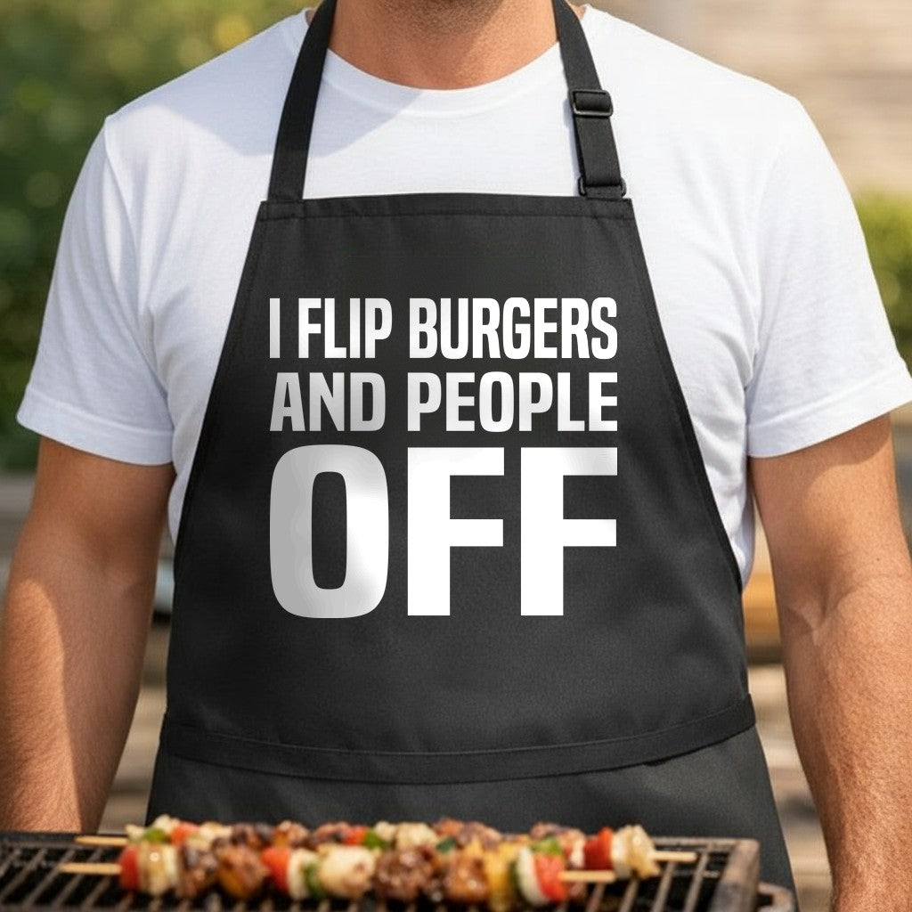 Black BBQ apron featuring large white bold text saying I Flip Burgers And People Off in a simple block style design