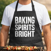 Black apron with large white text reading Baking Spirits Bright in three stacked lines in bold block letters