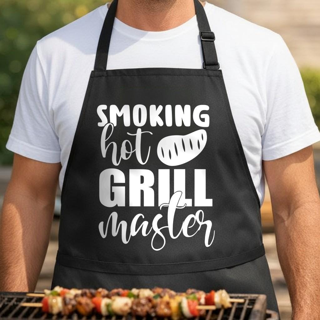 Smoking Hot Grill Master black BBQ apron, torso close-up: Black apron with white text reading 'Smoking Hot Grill Master' and a stylized steak graphic in bold and script fonts
