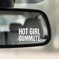 Close-up of the Hot Girl Commute white vinyl decal in the corner of a rear-view mirror