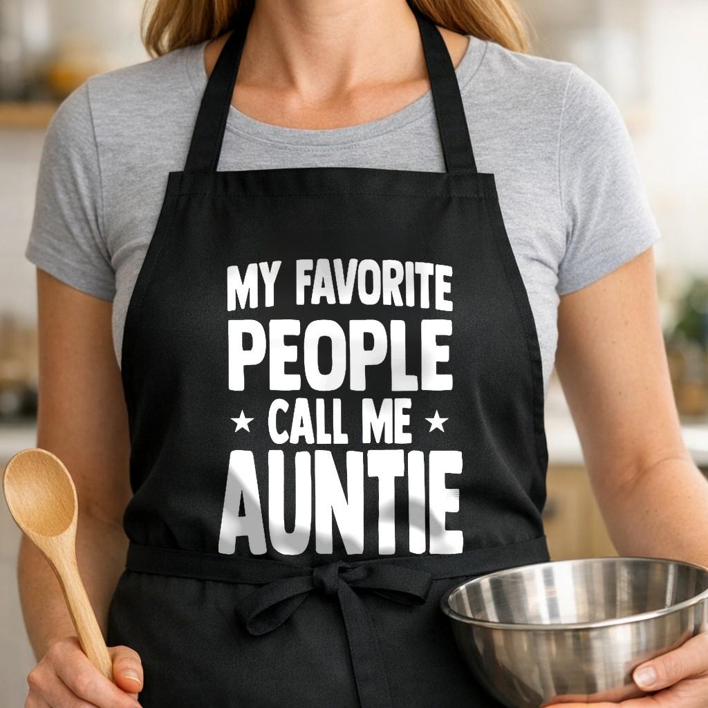 My Favorite People Call Me Auntie black BBQ apron, woman torso close-up: Black apron with large bold white text saying My Favorite People Call Me Auntie in all caps with two stars on sides