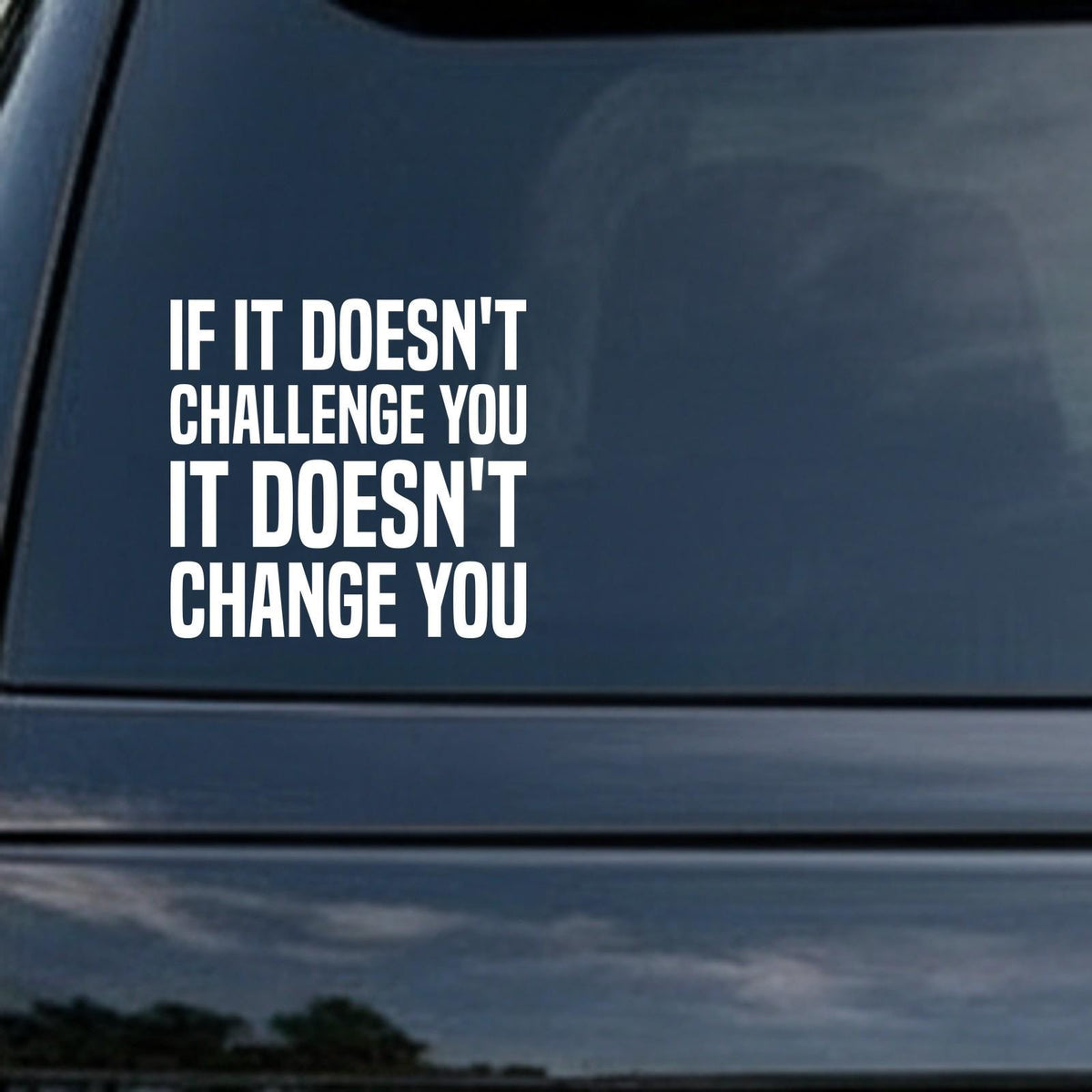 If It Doesn't Challenge You, It Doesn't Change You car decal in the small 6 inch size, shown in the corner of a rear window