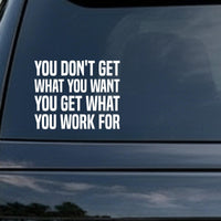 You Don't Get What You Want, You Get What You Work For car decal in the small 6 inch size, shown in the corner of a rear window