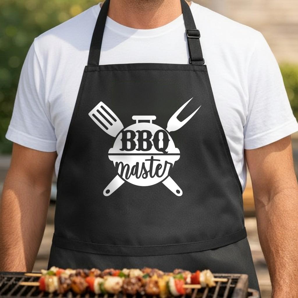 BBQ Master black BBQ apron, torso close-up: Black apron with white graphic showing a grill, spatula and fork crossed behind it and the words BBQ master in bold and script fonts