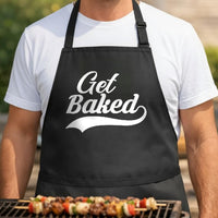 Get Baked black BBQ apron, torso close-up: Black apron with large white script text reading 'Get Baked' in bold, playful style on front