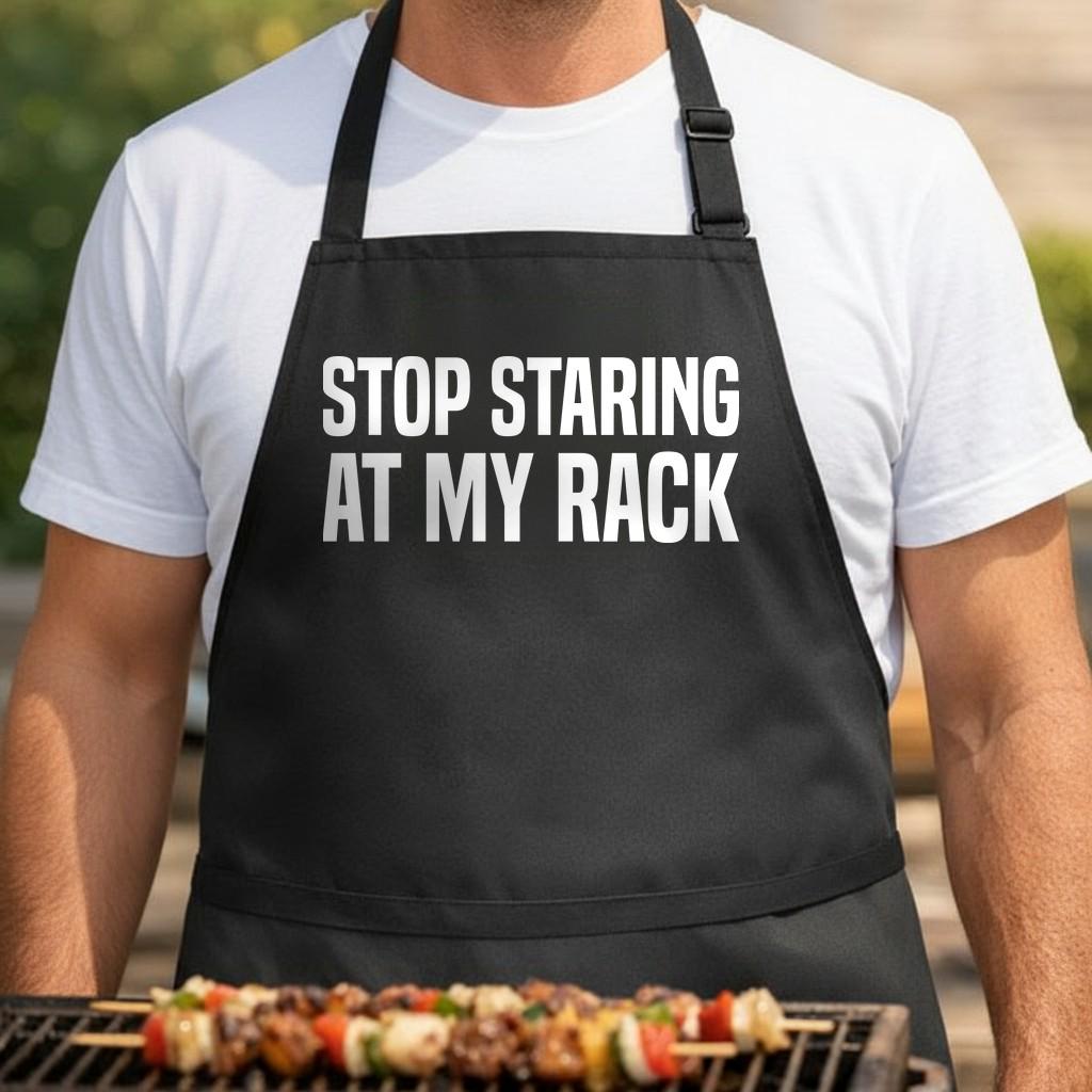 Stop Staring at My Rack black BBQ apron, torso close-up: Black apron with bold white uppercase text saying Stop Staring at My Rack in a simple sans serif font.